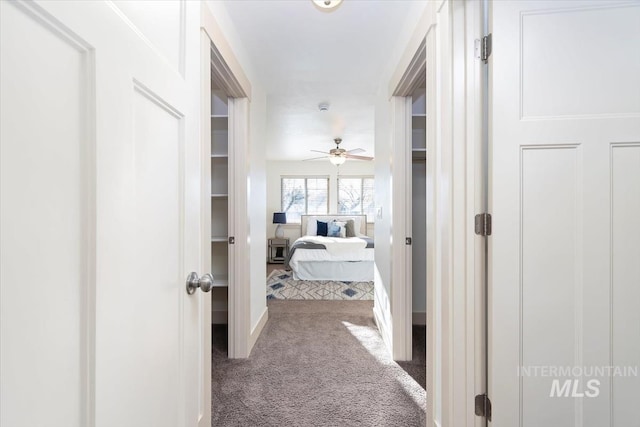 corridor featuring baseboards and carpet