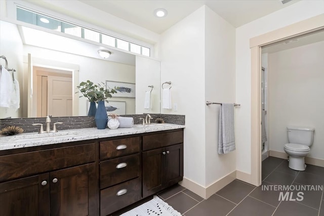 full bath featuring tile patterned flooring, toilet, and a sink