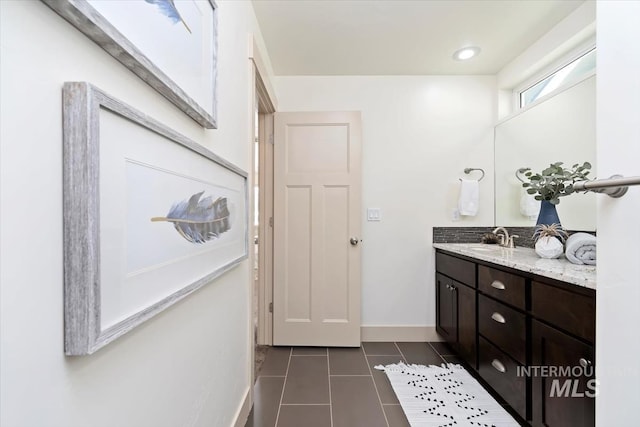 bathroom featuring tile patterned flooring, vanity, and baseboards