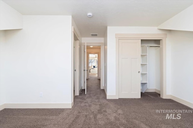 unfurnished bedroom featuring carpet flooring, baseboards, visible vents, and a closet