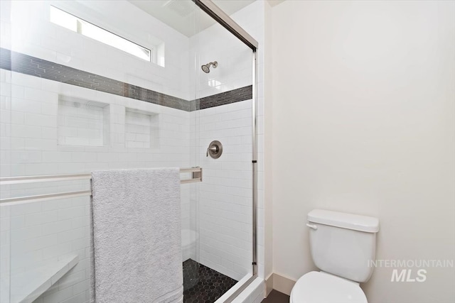 full bathroom featuring toilet and a stall shower