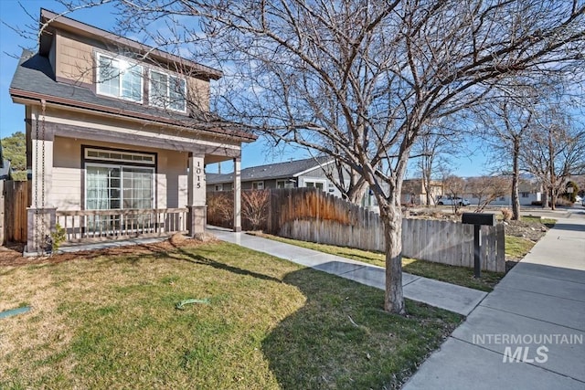 view of front facade featuring a porch, a front yard, and fence