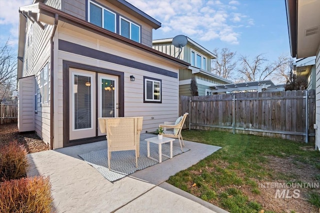 back of house with french doors, a patio, a yard, and a fenced backyard