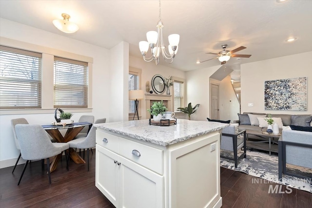 kitchen featuring a kitchen island, decorative light fixtures, open floor plan, dark wood-style floors, and white cabinetry