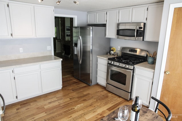 225 E Bayview, Boise, ID 83706 - kitchen with stainless steel appliances, light wood finished floors, light countertops, and white cabinetry