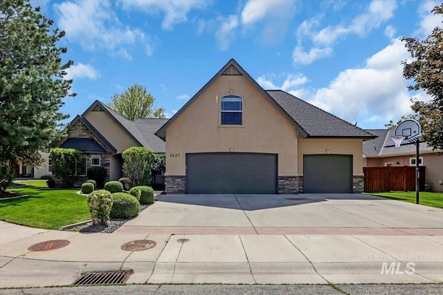 2627 E Moog St, Meridian, ID 83646 - view of front of property featuring stucco siding, stone siding, driveway, and an attached garage