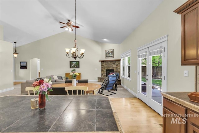 2627 E Moog St, Meridian, ID 83646 - dining room featuring a ceiling fan, arched walkways, a fireplace, light wood-type flooring, and a chandelier