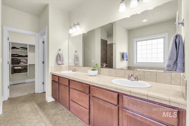 2627 E Moog St, Meridian, ID 83646 - full bathroom featuring double vanity, tile patterned floors, a spacious closet, and a tile shower