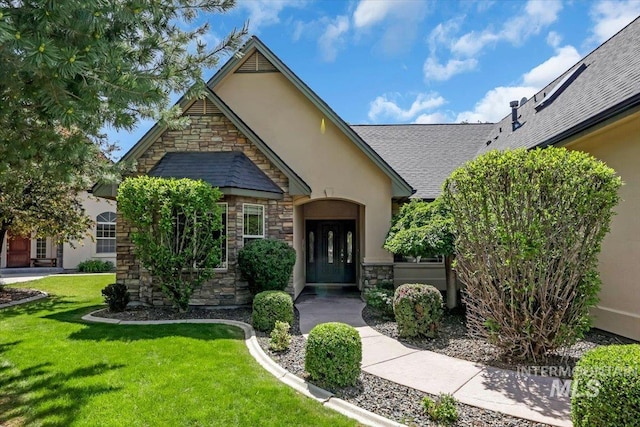 2627 E Moog St, Meridian, ID 83646 - view of front facade featuring stone siding, stucco siding, a front yard, and roof with shingles