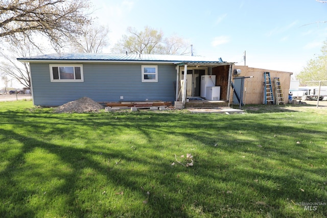 rear view of house with a yard and metal roof