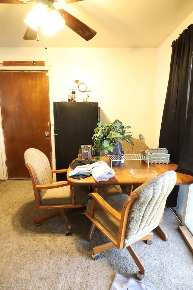 dining area with a ceiling fan and carpet