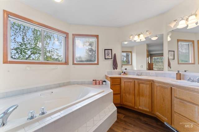 bathroom featuring a bath, a healthy amount of sunlight, and a sink