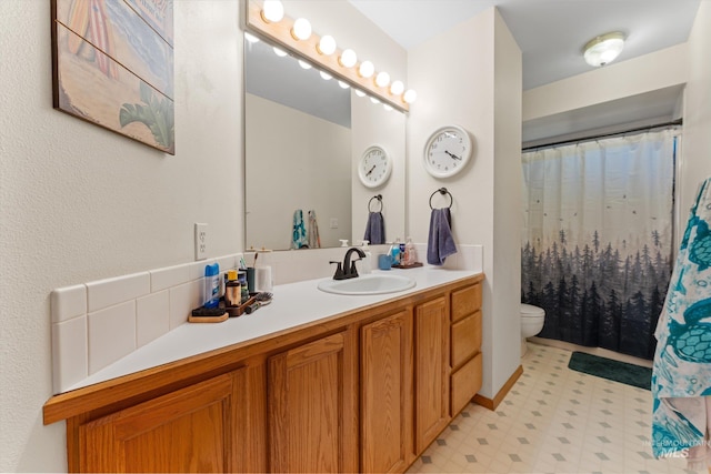 bathroom featuring tile patterned floors, vanity, a shower with shower curtain, and toilet