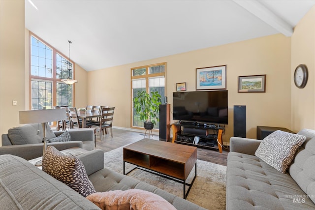 living area with baseboards, wood finished floors, high vaulted ceiling, and beamed ceiling