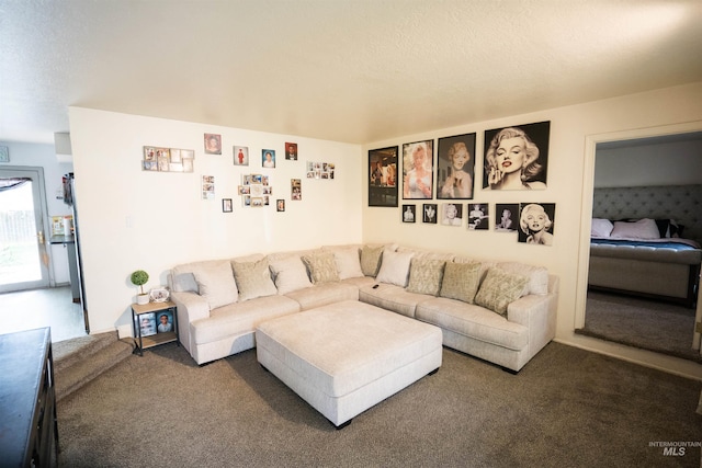 living room featuring a textured ceiling and dark carpet