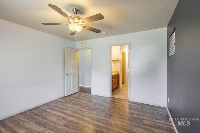 9885 W Tilmont St, Boise, ID 83709 - unfurnished bedroom featuring wood finished floors, baseboards, and connected bathroom