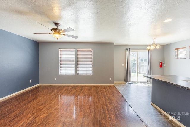9885 W Tilmont St, Boise, ID 83709 - empty room with a chandelier, a textured ceiling, wood finished floors, ceiling fan, and baseboards