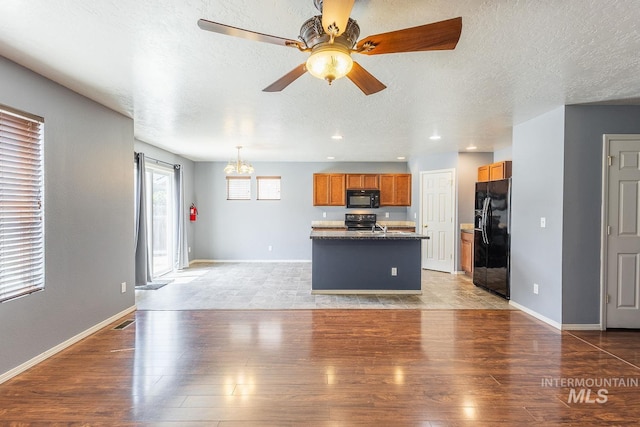 9885 W Tilmont St, Boise, ID 83709 - kitchen featuring black appliances, light wood-type flooring, a textured ceiling, a ceiling fan, and brown cabinetry