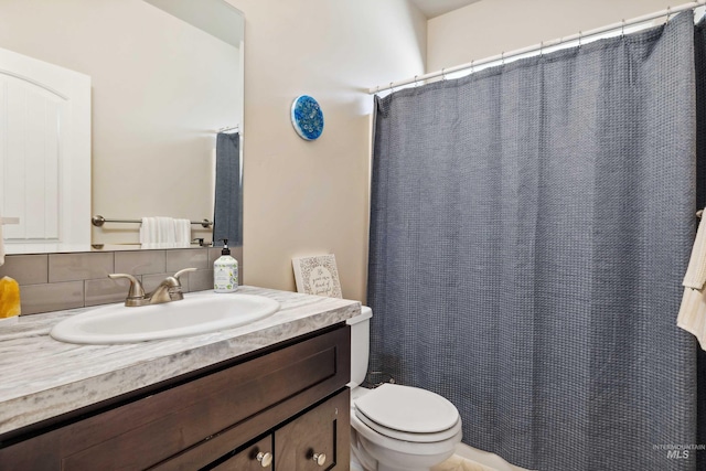 bathroom with tasteful backsplash, vanity, a shower with curtain, and toilet