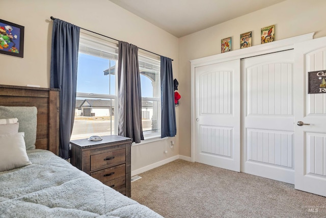 bedroom with a closet, baseboards, and carpet
