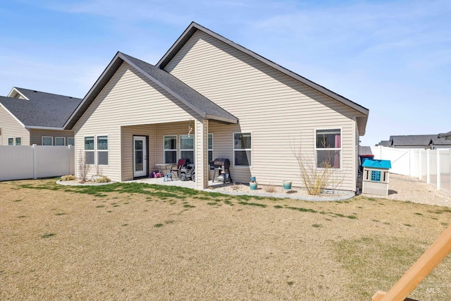back of house featuring a fenced backyard, a patio, and a lawn
