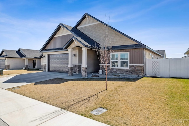 craftsman inspired home featuring concrete driveway, stone siding, board and batten siding, a garage, and fence