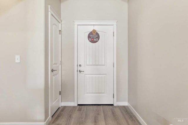 doorway to outside with baseboards and wood finished floors