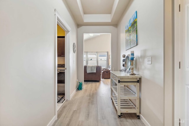 corridor with baseboards and wood finished floors