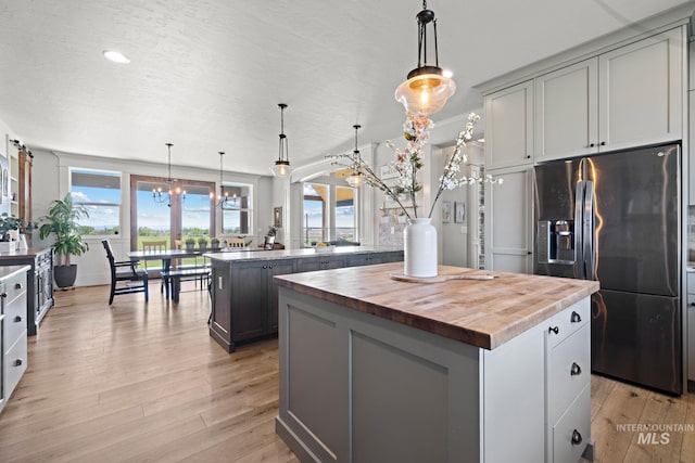 17293 Goodson Rd, Caldwell, ID 83607 - kitchen with stainless steel fridge, a kitchen island, light wood-style flooring, and wooden counters