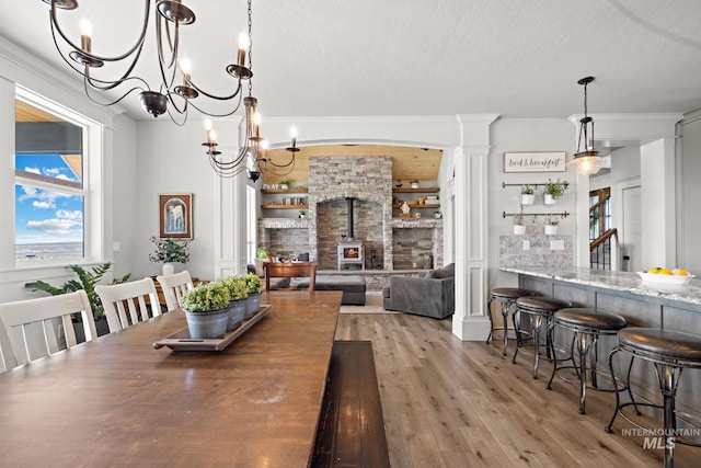 17293 Goodson Rd, Caldwell, ID 83607 - dining room with a wood stove, crown molding, a textured ceiling, and wood finished floors