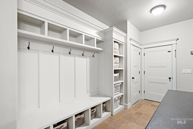 17293 Goodson Rd, Caldwell, ID 83607 - mudroom featuring a textured ceiling and stone tile floors