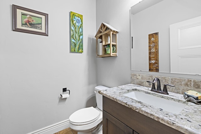 17293 Goodson Rd, Caldwell, ID 83607 - bathroom featuring tasteful backsplash, baseboard heating, toilet, vanity, and baseboards