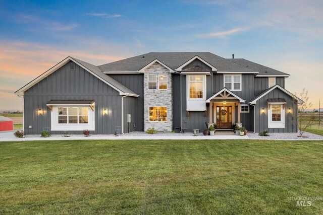 17293 Goodson Rd, Caldwell, ID 83607 - view of front facade featuring board and batten siding, a front yard, and a shingled roof