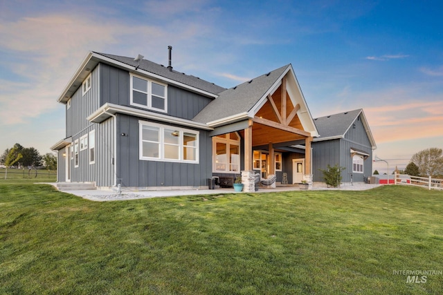 17293 Goodson Rd, Caldwell, ID 83607 - back of house with board and batten siding, a lawn, fence, and a patio