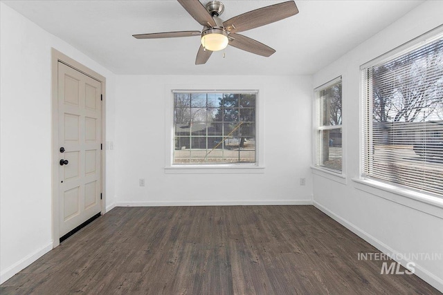 unfurnished room with dark wood-style floors, baseboards, and a healthy amount of sunlight