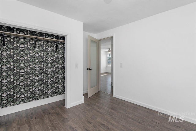 empty room featuring dark wood-style floors and baseboards