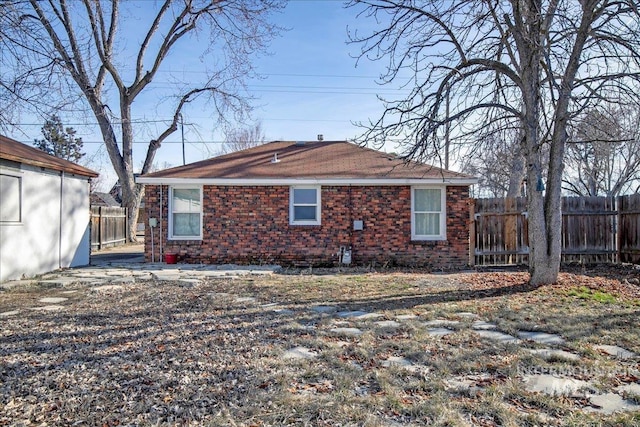 exterior space featuring brick siding and fence