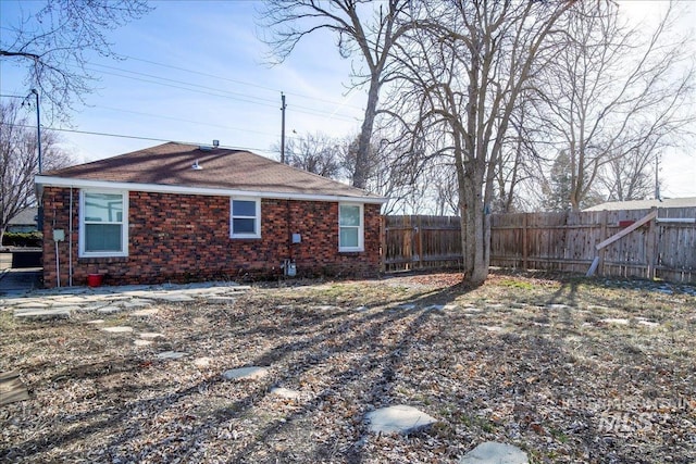 exterior space featuring brick siding and fence