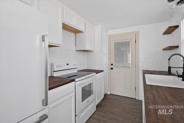 kitchen featuring white appliances, a sink, white cabinetry, open shelves, and dark countertops