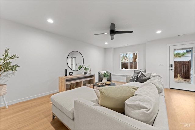 living room featuring ceiling fan, light hardwood / wood-style flooring, and plenty of natural light