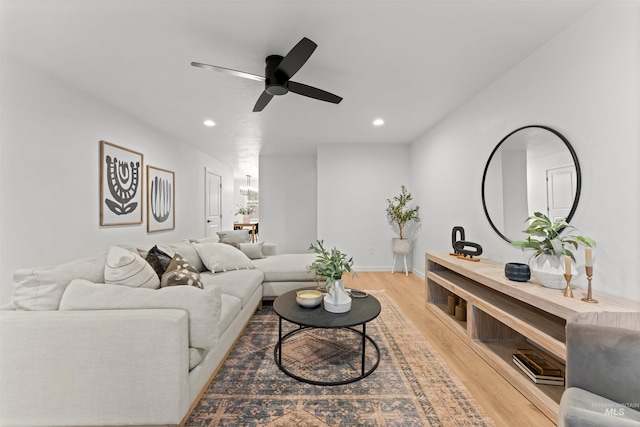 living room with light hardwood / wood-style flooring and ceiling fan