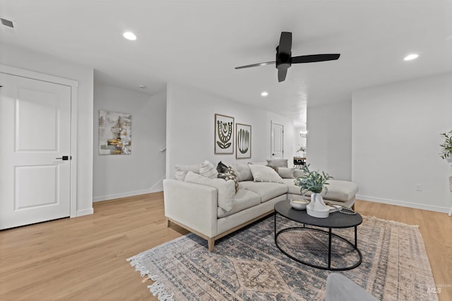 living room with light hardwood / wood-style floors and ceiling fan