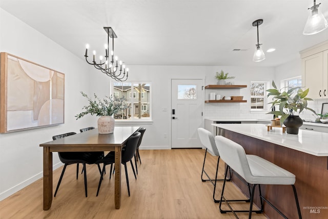 dining room with light hardwood / wood-style flooring and a notable chandelier