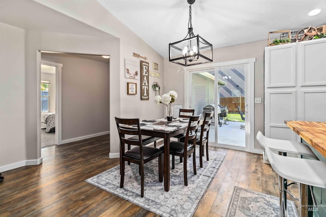 dining area featuring a chandelier, hardwood / wood-style flooring, and baseboards