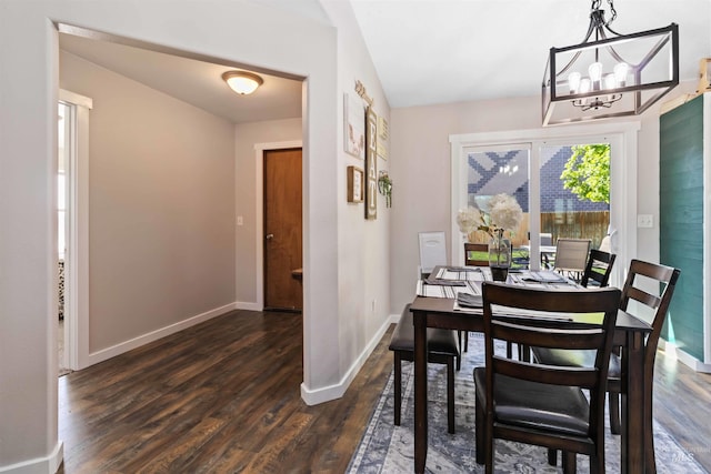 dining area featuring a chandelier, dark wood-style floors, and baseboards