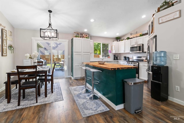 kitchen featuring wooden counters, stainless steel appliances, white cabinets, dark wood-style flooring, and recessed lighting