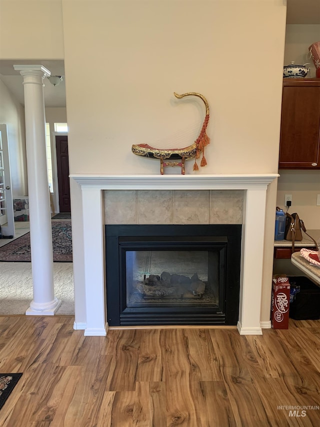 details featuring hardwood / wood-style floors, a fireplace, and decorative columns