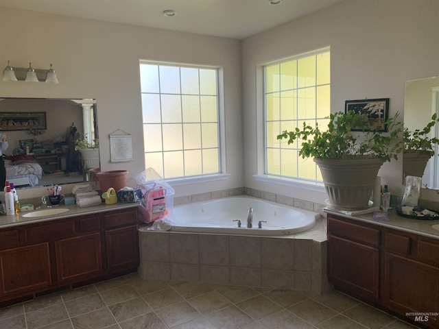 bathroom with vanity, plenty of natural light, and tiled bath