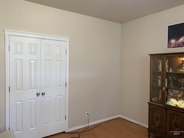 unfurnished bedroom with wood-type flooring and a closet