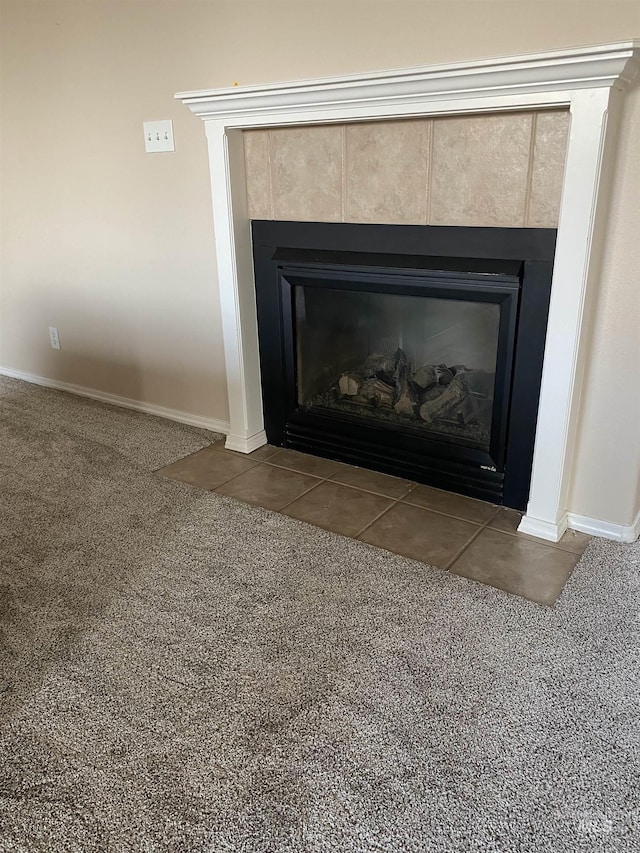 room details featuring a tile fireplace and carpet